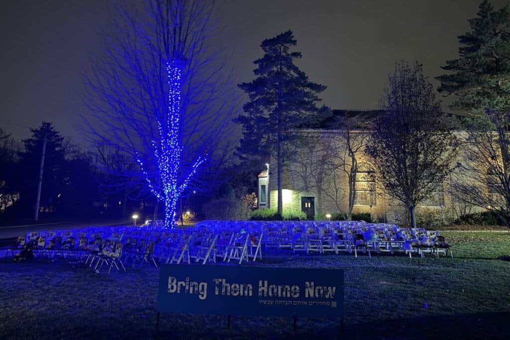The Am Shalom chair installation for hostages and Hope Tree at night